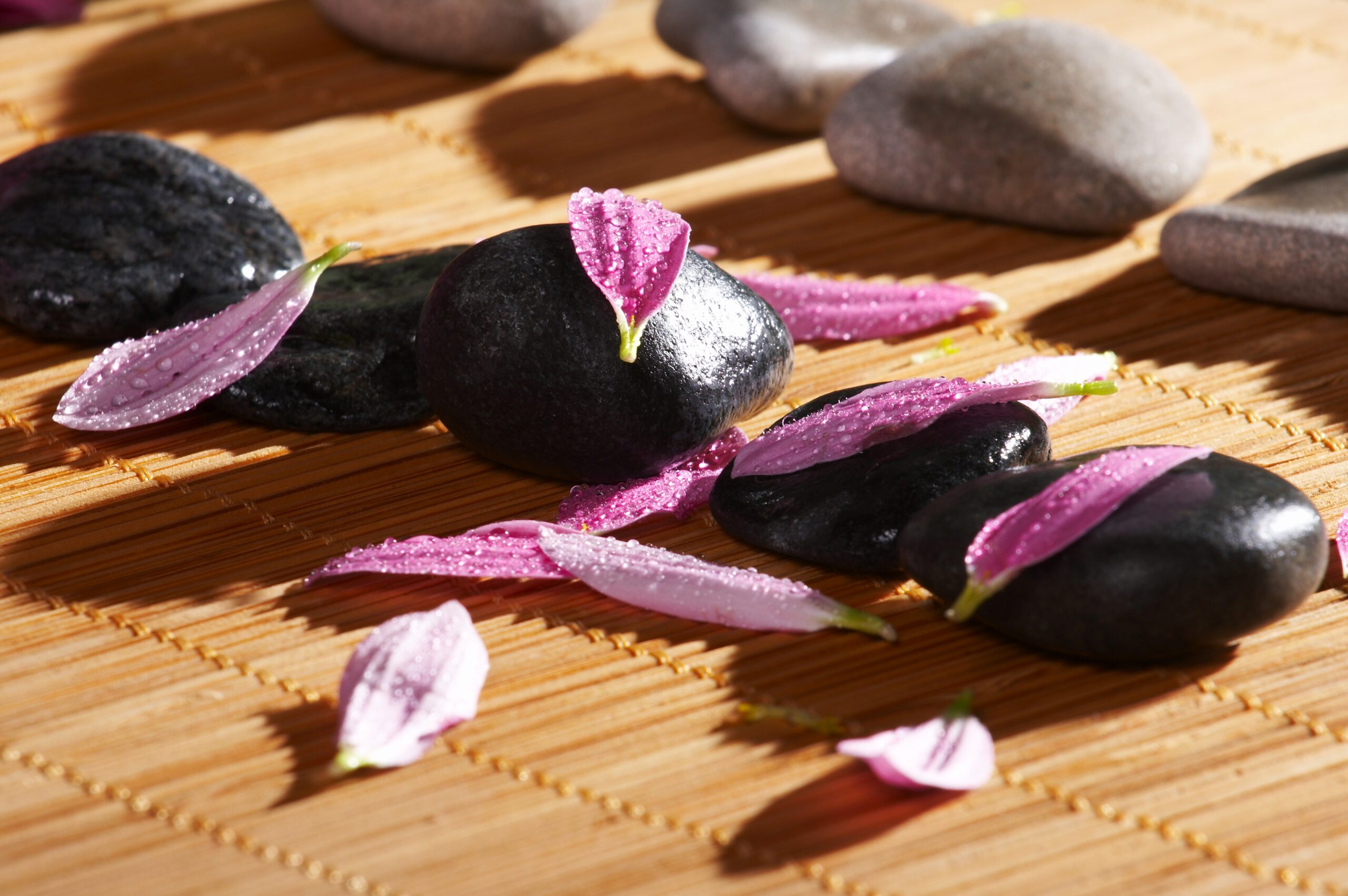 Handcrafted black fabric fish with pink accents on a bamboo mat.