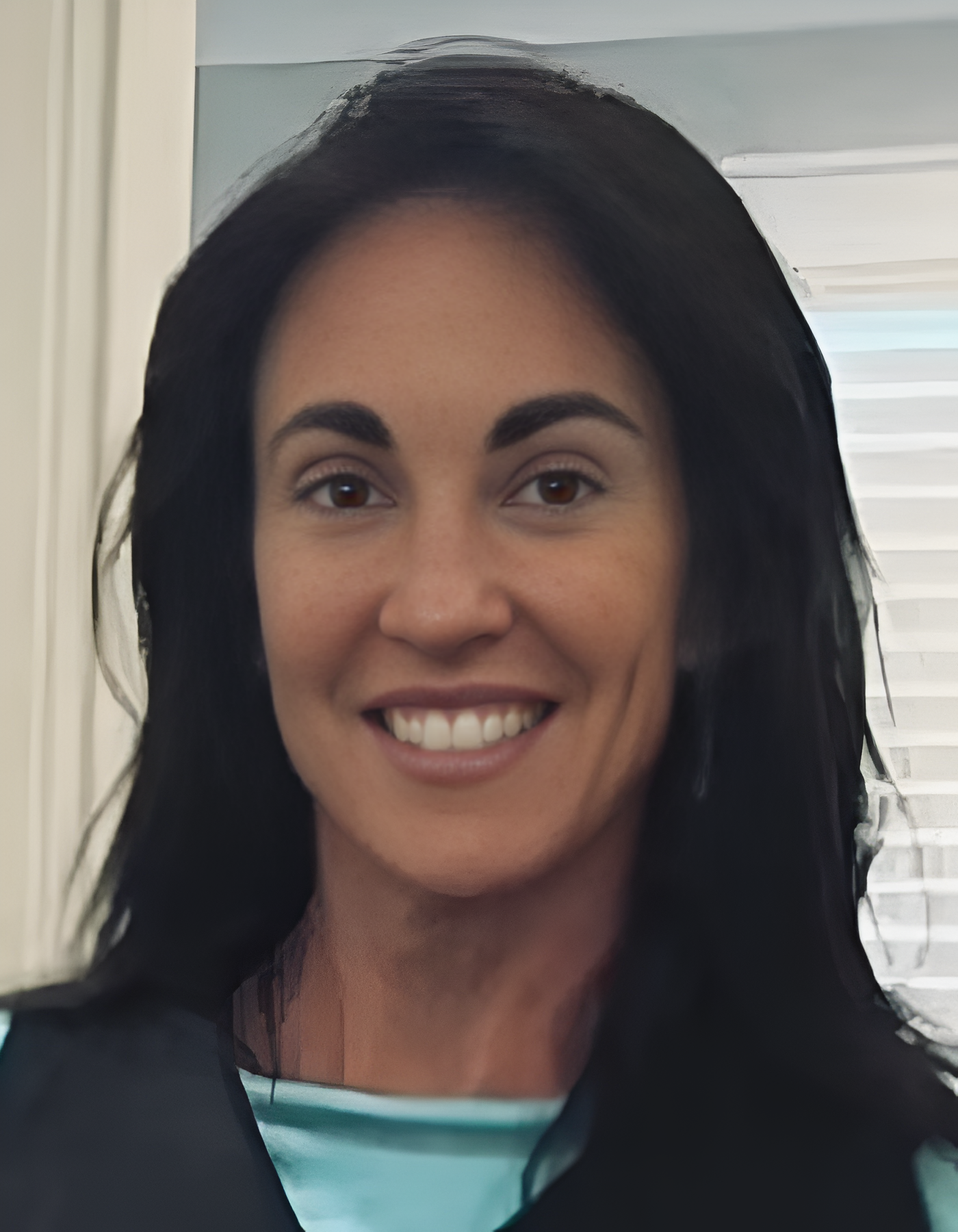 Smiling woman with long dark hair in a bright room.